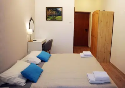 a bedroom with two beds with blue and white pillows at Dom Casimi in Kraków