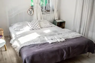 a bed with two towels on it in a bedroom at Apartamenty Stacja Kasina in Kasina Wielka