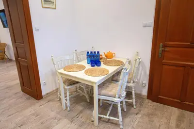 a dining room table with chairs and a white table at Apartamenty Stacja Kasina in Kasina Wielka