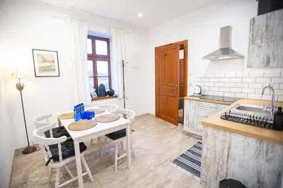 a kitchen with a table and chairs and a sink at Apartamenty Stacja Kasina in Kasina Wielka