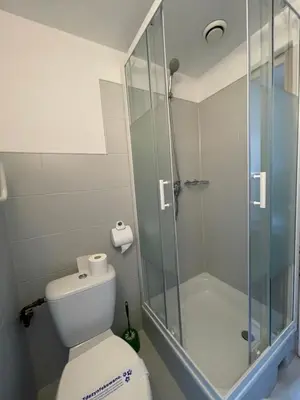 a bathroom with a toilet and a glass shower at Pokoje Gościnne Unikat - Self check in in Kraków