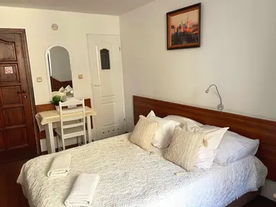 a bedroom with a bed and a table and a mirror at Pokoje Gościnne Unikat - Self check in in Kraków