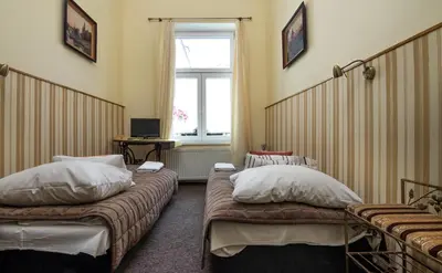 a hotel room with two beds and a window at Pokoje Gościnne Unikat - Self check in in Kraków