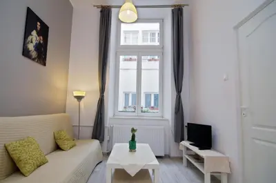 a living room with a couch and a window at Pokoje Gościnne Unikat - Self check in in Kraków