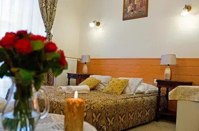 a hotel room with a bed with a vase of flowers at Pokoje Gościnne Unikat - Self check in in Kraków