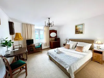 a bedroom with a bed and a table and a desk at Pokoje Gościnne Unikat - Self check in in Kraków