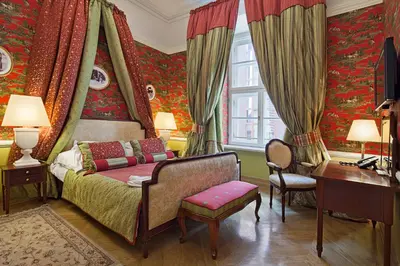 a bedroom with a bed and a desk and curtains at The Bonerowski Palace Boutique Hotel in Kraków