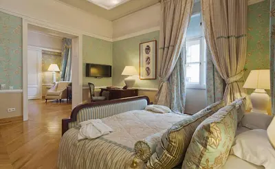 a bedroom with a bed and a living room at The Bonerowski Palace Boutique Hotel in Kraków