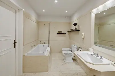 a bathroom with a tub and a toilet and a sink at The Bonerowski Palace Boutique Hotel in Kraków