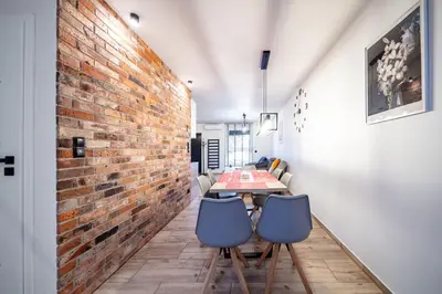 a dining room with a brick wall and a table and chairs at Apartament na Skarpie in Zator