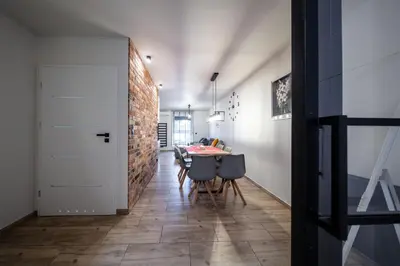 a dining room with a table and a brick wall at Apartament na Skarpie in Zator