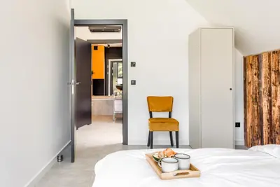 a bedroom with a bed with a tray of food and a chair at STODOŁY94 in Mordarka