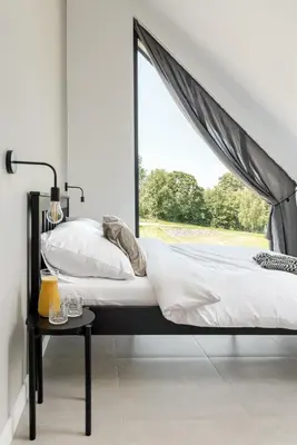 a bed with a canopy in a bedroom with a window at STODOŁY94 in Mordarka