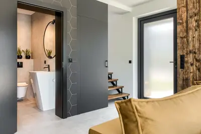 a living room with a couch and a bathroom at STODOŁY94 in Mordarka