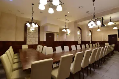 a large dining room with a long table and white chairs at Hotel Downtown Kraków in Kraków
