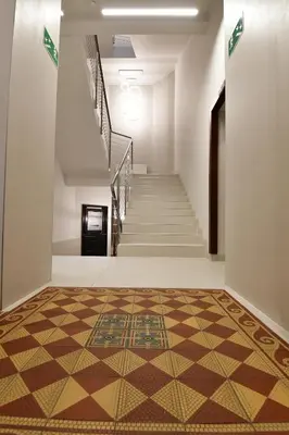 a hallway with a tile floor and stairs at Hotel Downtown Kraków in Kraków