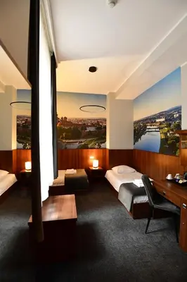 a hotel room with two beds and a desk at Hotel Downtown Kraków in Kraków