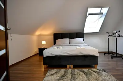 a bedroom with a bed with a large window at Apartament u Joli in Miejsce