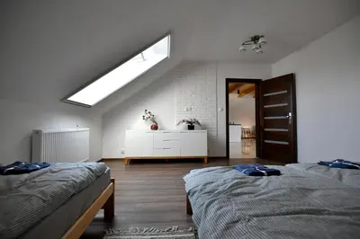 a attic bedroom with two beds and a skylight at Apartament u Joli in Miejsce