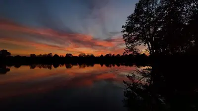 a sunset over a body of water with a tree at Apartament u Joli in Miejsce