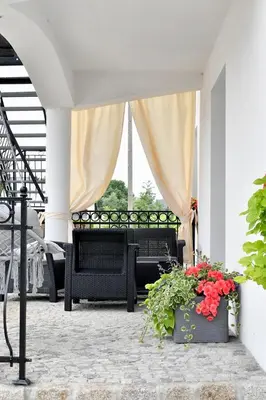 a patio with two benches and flowers on a porch at Apartament u Joli in Miejsce