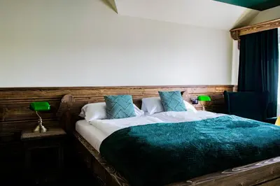 a bedroom with a large bed with blue pillows at Pokoje Gościnne Biały Bizon in Rabka