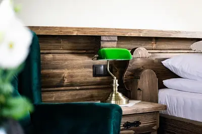 a green lamp on a table next to a bed at Pokoje Gościnne Biały Bizon in Rabka