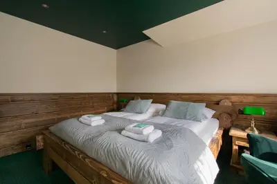a bedroom with a bed with towels on it at Pokoje Gościnne Biały Bizon in Rabka