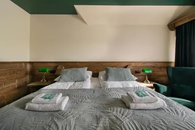 a bedroom with two beds with towels on them at Pokoje Gościnne Biały Bizon in Rabka