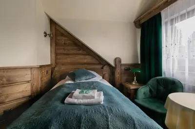 a bedroom with a bed with two towels on it at Pokoje Gościnne Biały Bizon in Rabka