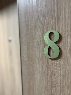 a wooden door with a green number on it at CozyStudio with Sauna in Kraków