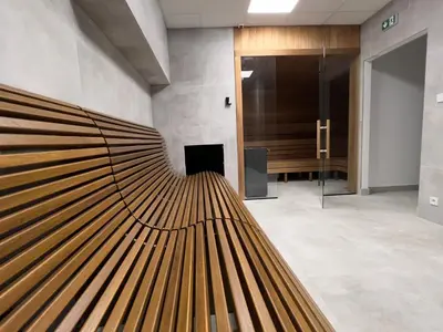 a lobby with a large wooden bench in a building at CozyStudio with Sauna in Kraków