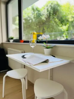 a white table with two chairs and a wine glass at CozyStudio with Sauna in Kraków