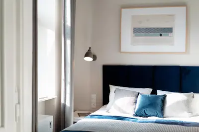 a bedroom with a bed with blue and white pillows at Kochanowskiego Family Apartments in Kraków