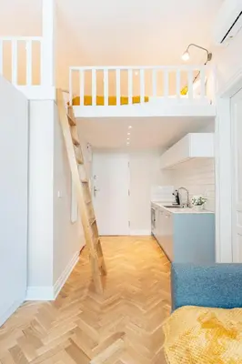 a room with a loft bed and a kitchen at Kochanowskiego Family Apartments in Kraków