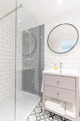 a bathroom with a sink and a glass shower at Kochanowskiego Family Apartments in Kraków
