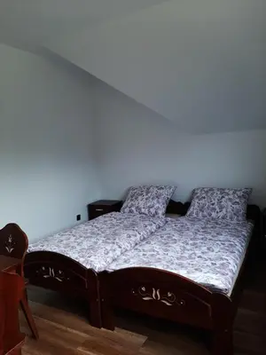 a bed in a room with a white wall at Dom Dobre Miejsce in Zawoja