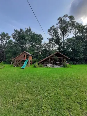 a large yard with a house and a playground at Dom Dobre Miejsce in Zawoja