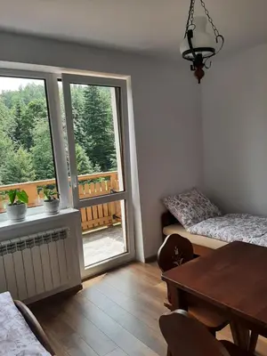 a living room with a dining table and a window at Dom Dobre Miejsce in Zawoja