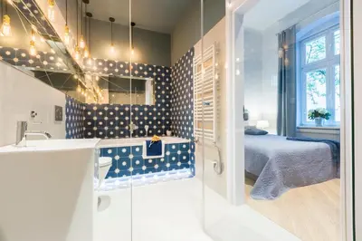 a bathroom with a sink and a bed in a room at Cadena Gallery Apartments Wyspiański in Kraków