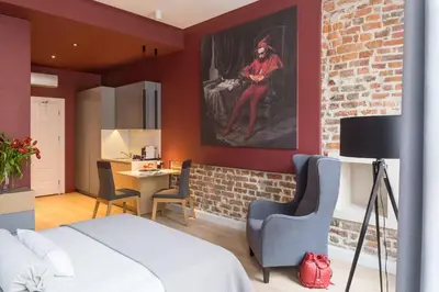 a bedroom with a bed and a brick wall at Cadena Gallery Apartments Matejko in Kraków