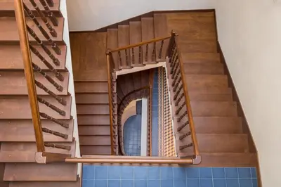 a spiral staircase in a building with a blue tile floor at Cadena Gallery Apartments Matejko in Kraków