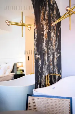 a bathroom with a bath tub and a bed at Aparthotel ZATOR Glam 52 jacuzzi in Zator
