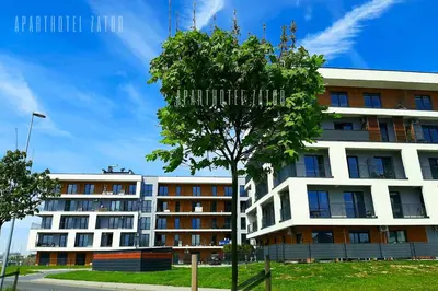 a building with a tree in front of it at Aparthotel ZATOR Glam 52 jacuzzi in Zator