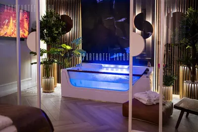 a bath tub in a room with plants at Aparthotel ZATOR Retro 66 jacuzzi in Zator