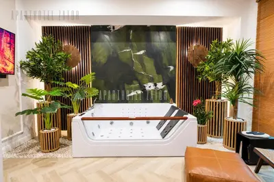 a bath tub in a room with potted plants at Aparthotel ZATOR Retro 66 jacuzzi in Zator