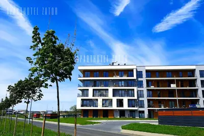 a large white building with a tree in front of it at Aparthotel ZATOR Retro 66 jacuzzi in Zator