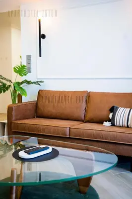 a living room with a brown couch and a glass table at Aparthotel ZATOR Retro 66 jacuzzi in Zator