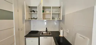 a small kitchen with a sink and white cabinets at Apartamenty Nikodem in Old Town - Krakow center in Kraków