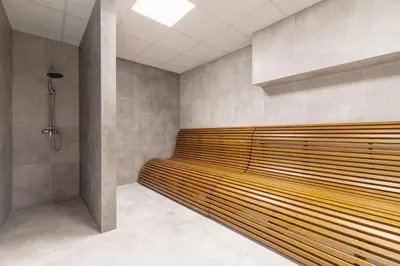 a bathroom with a wooden bench in a room at Cozy Studio Apartments Sauna & AC Kraków by Noclegi Renters in Kraków